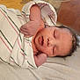 newborn, baby, swaddle, striped_blanket, sleeping, closed_eyes, infant, hand, arm, face, hair, peaceful, portrait, lying_down, cozy, indoors, hospital, tiny_fingers, skin, cuddle
