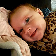 Anna is registered to the contest to win money with this photo: baby, blanket, child, closeup, clothing, cozy, cute, eyeball, face, happy, head, infant, leopard_print, person, pink, portrait, resting, skin, smile, soft