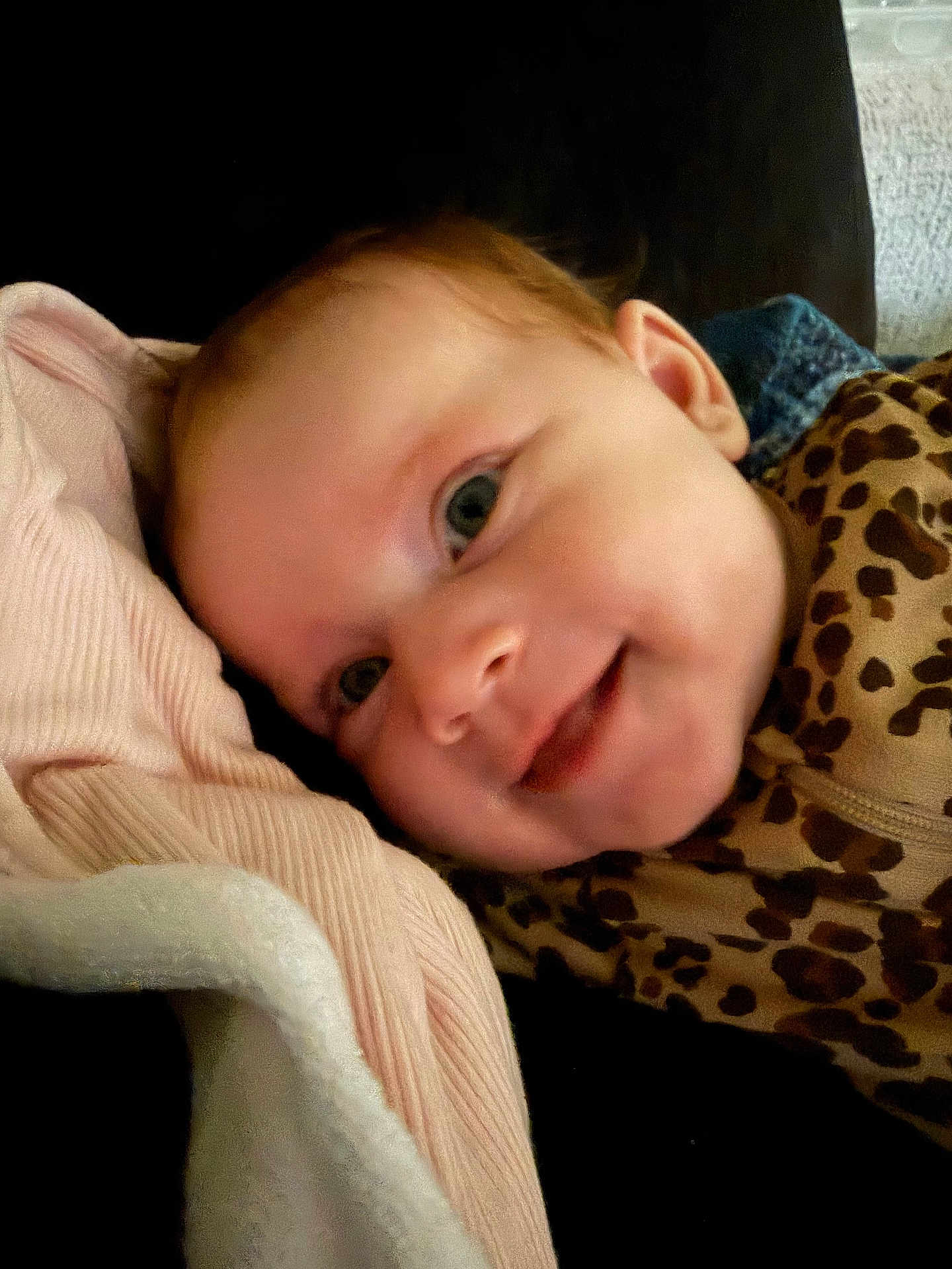 Anna is registered to the contest to win money with this photo: baby, blanket, child, closeup, clothing, cozy, cute, eyeball, face, happy, head, infant, leopard_print, person, pink, portrait, resting, skin, smile, soft