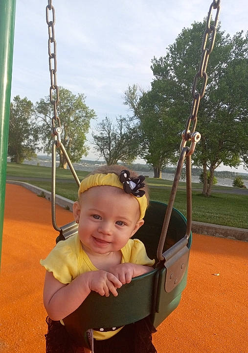 Faith is registered to the contest to win money with this photo: baby, black, city, cloud, fun, grass, happy, human_settlement, joy, leisure, outdoor_play_equipment, person, plant, playground, public_space, recreation, sky, smile, summer, swing
