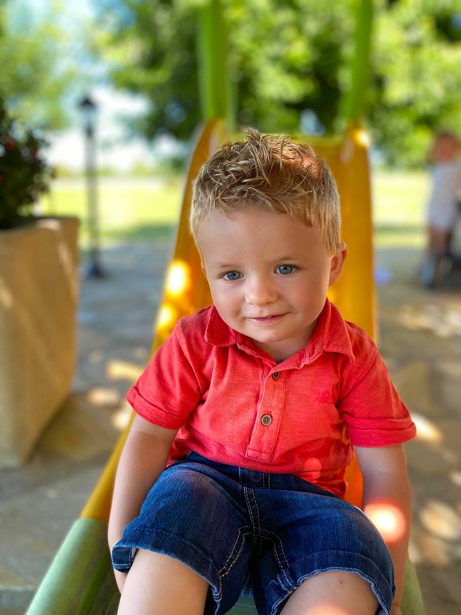 Gabin a rejoint le concours — aidez-le/la à gagner de superbes lots ! child, denim, eye, fun, grass, happy, joy, leisure, orange, outdoor_play_equipment, person, plant, recreation, sitting, skin, smile, standing, summer, t_shirt, toddler