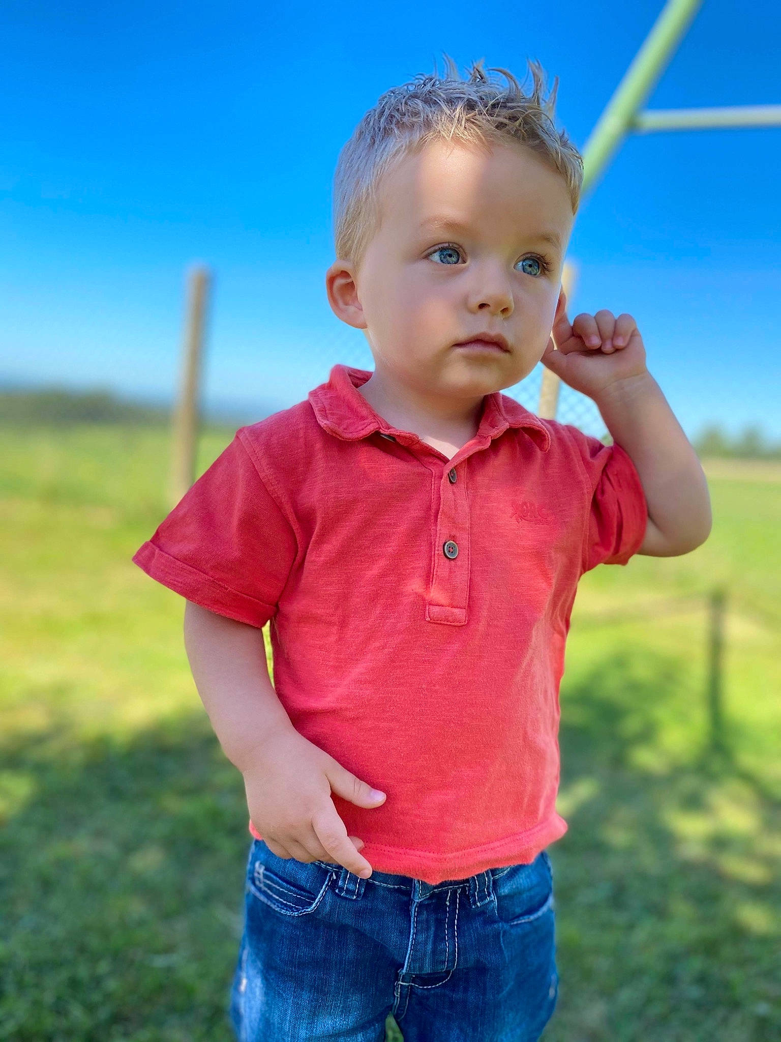 Gabin participe au concours pour gagner de l'argent avec cette photo : baby_toddler_clothing, chin, clothing, face, flash_photography, fun, gesture, grass, grassland, happy, jeans, leisure, people, people_in_nature, person, skin, sky, sleeve, standing, summer