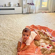 Niema a rejoint le concours — aidez-le/la à gagner de superbes lots ! baby, blanket, carpet, child, indoor, living_room, onesie, person, floor, furniture, window, chair, speaker, soft_light, couch, cute, infant, home, toddler, playtime