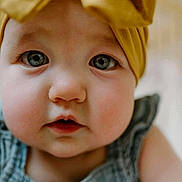 Ivy is registered to the contest to win money with this photo: baby, close_up, face, headband, blue_clothing, chubby_cheeks, big_eyes, curious, infant, portrait, cute, child, soft_lighting, indoors, skin, person, young, expression, adorable, headwear