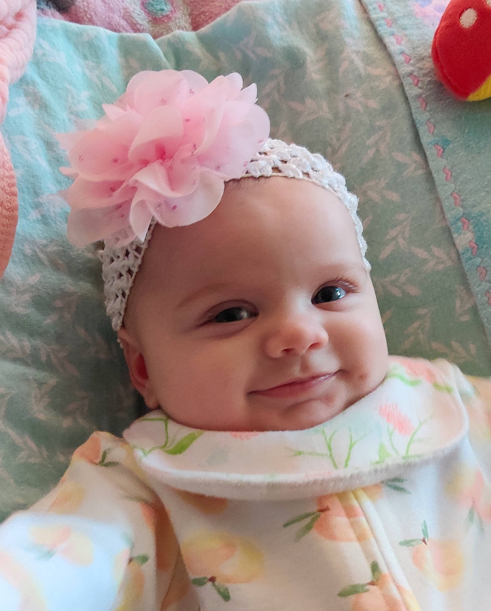 Laney is registered to the contest to win money with this photo: baby, baby_toddler_clothing, cheek, child, eye, face, flower, happy, headband, headpiece, headwear, iris, lip, pattern, person, petal, pink, product, skin, smile