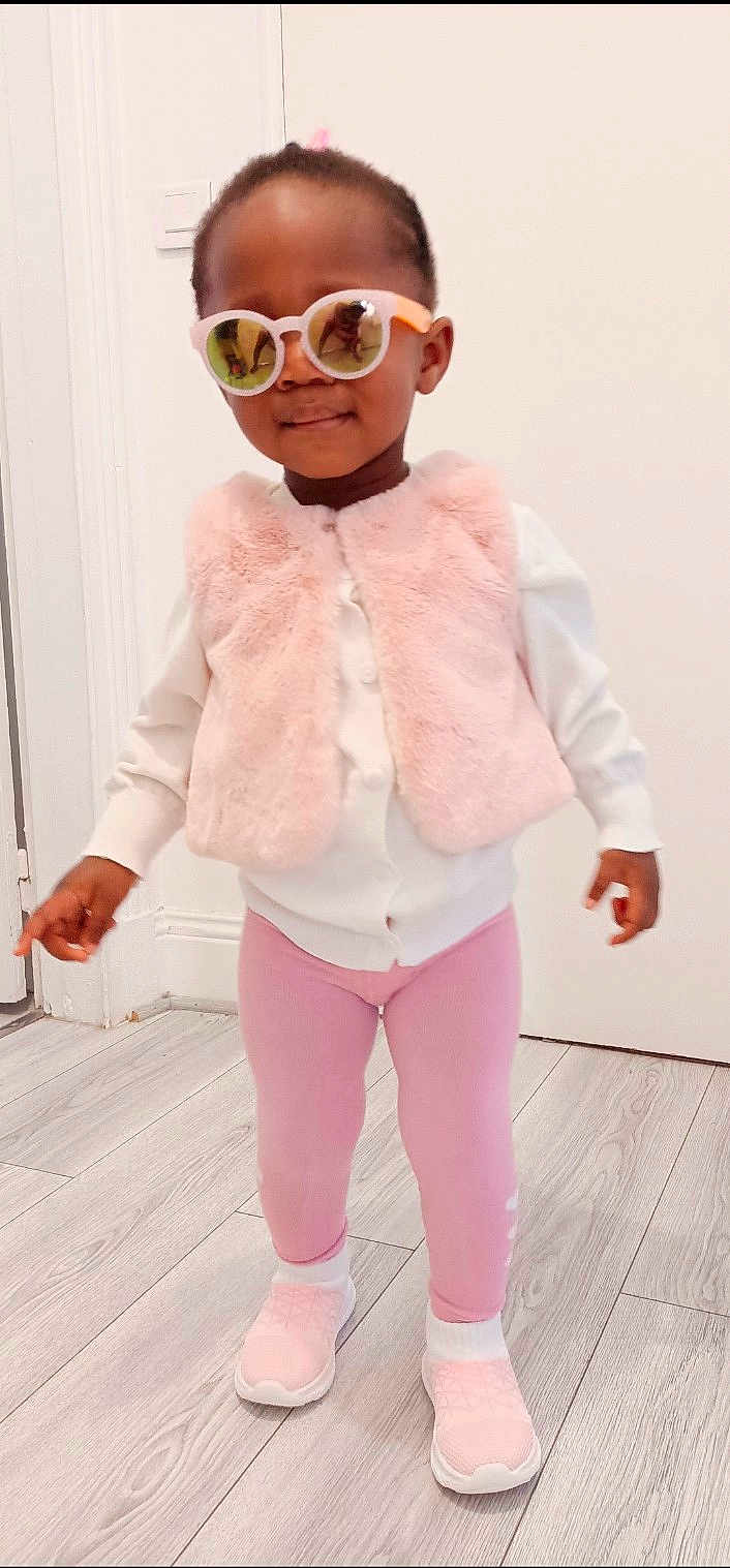 Aiyanna participe au concours pour gagner de l'argent avec cette photo : apparel, casual_wear, child, cool, cute, fashion, happy, indoor, leggings, person, pink_vest, portrait, smile, sneakers, standing, sunglasses, toddler, white_sweater, wooden_floor, young_child