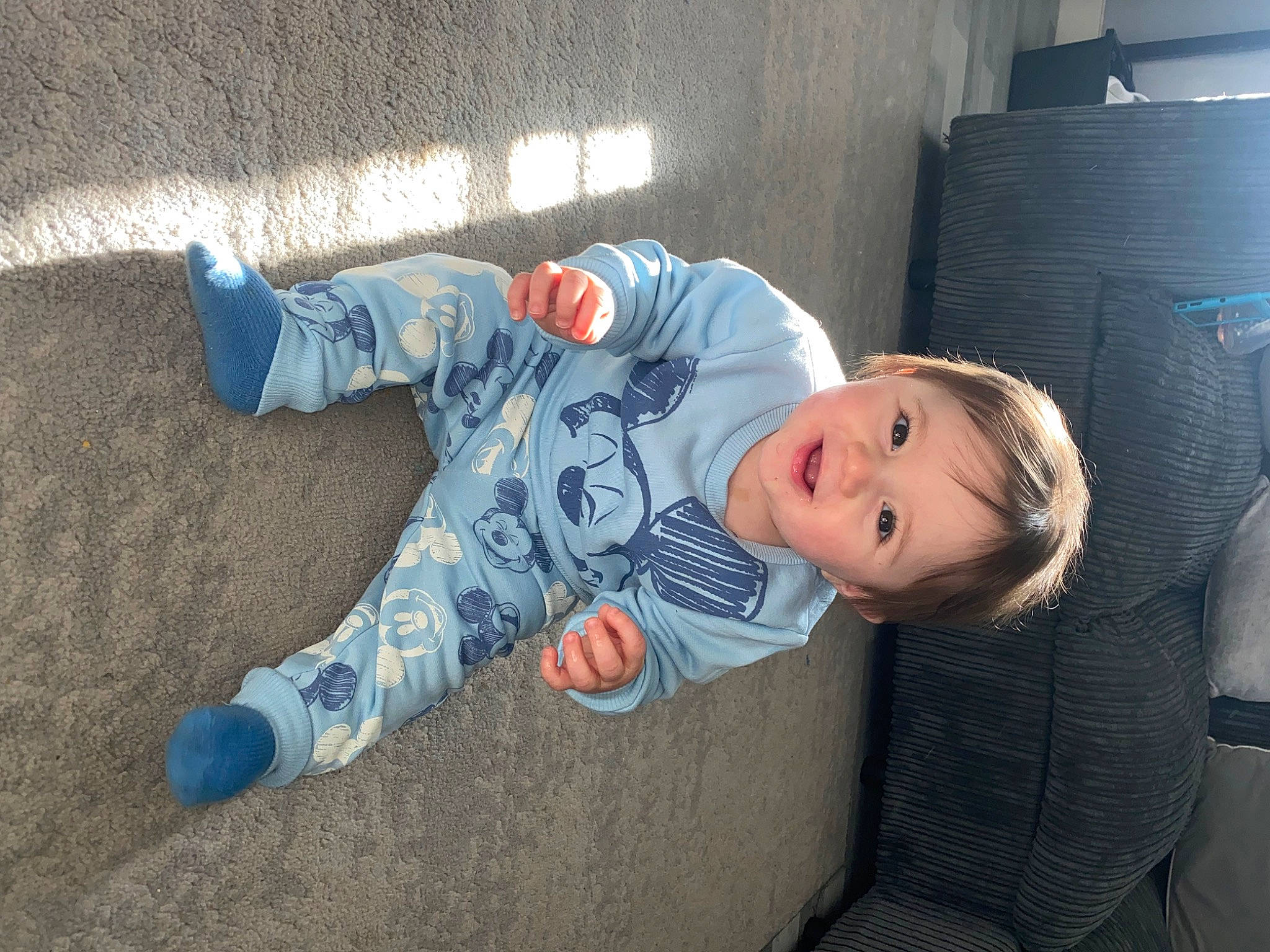 Bailey is registered to the contest to win money with this photo: baby, baby_toddler_clothing, child, comfort, eye, face, floor, flooring, fun, head, mammal, nap, person, room, sitting, sleeve, smile, sock, t_shirt, toddler