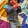 baby, infant, hooded_jacket, striped_pants, pacifier, blanket, patterned_blanket, clothing, lying_down, small_hands, face, cute, indoors, fabric, colorful, portrait, newborn, child, resting, soft_lighting