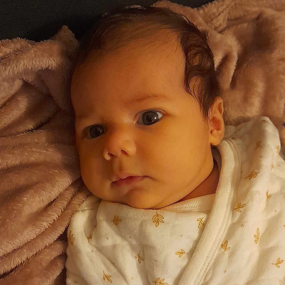 Léa a rejoint le concours — aidez-le/la à gagner de superbes lots ! baby, blanket, child, clothing, cozy, curious, cute, expression, face, head, indoors, infant, lying_down, newborn, portrait, skin, sleepwear, small_hands, soft_texture, warm