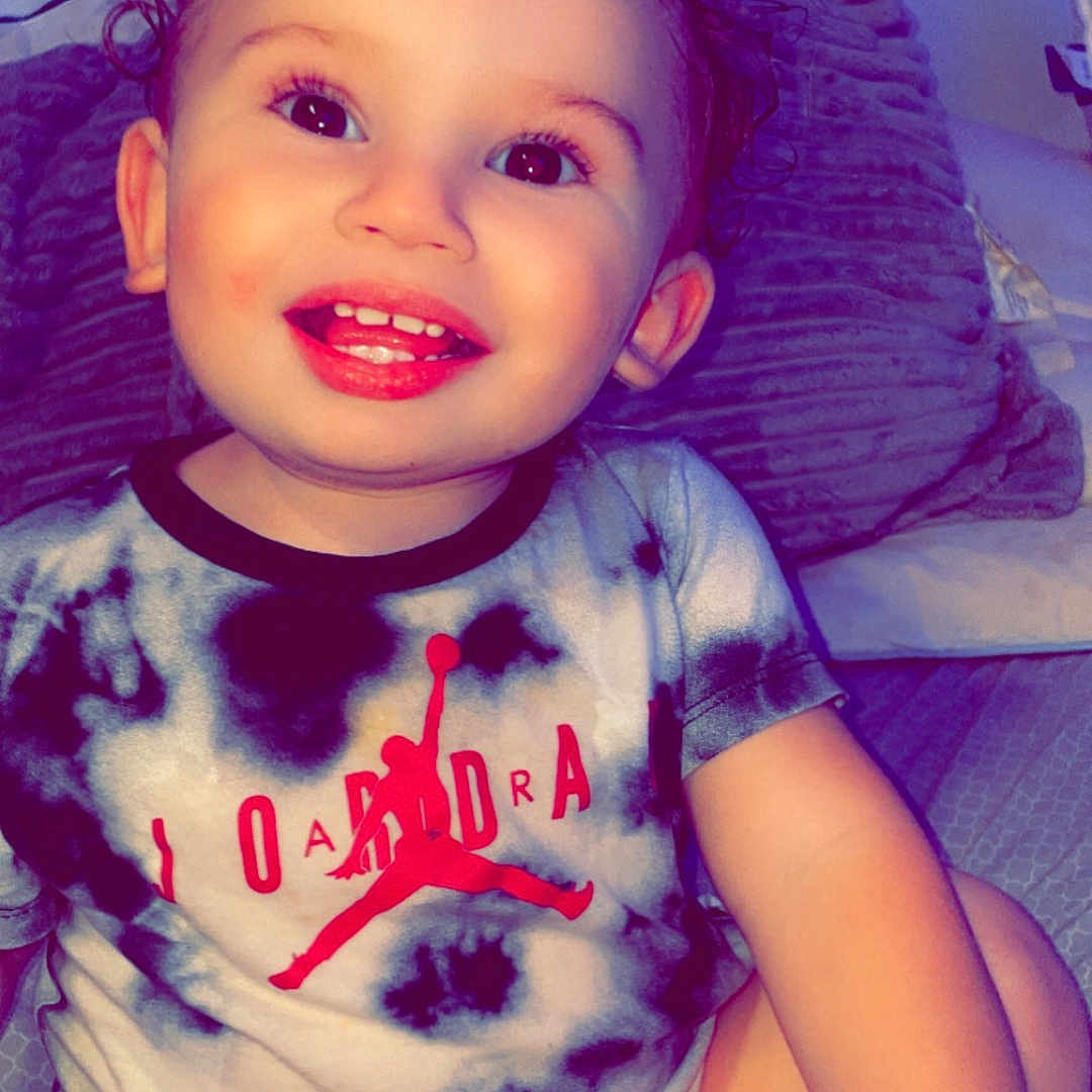 Kaiveon is registered to the contest to win money with this photo: baby, bodypart, clothing, cosmetics, couch, cushion, face, furniture, happy, head, homedecor, indoors, lipstick, mouth, person, photography, portrait, smile, t_shirt, teeth