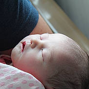Sienna is registered to the contest to win money with this photo: newborn, baby, sleeping, blanket, pink, infant, person, closeup, soft_light, peaceful, face, head, human, skin, portrait, resting, caring, tender, indoors, wrapped