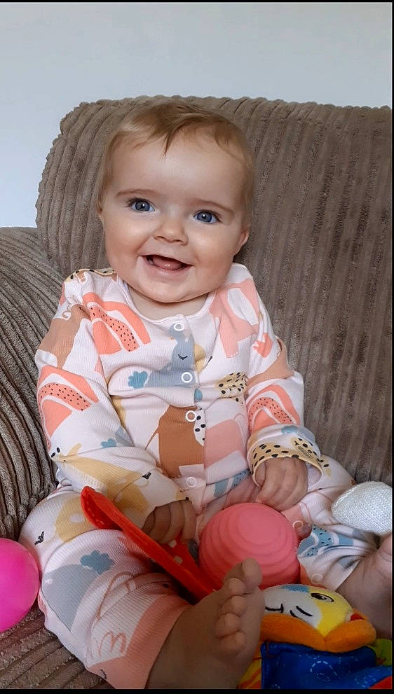 Emily joined the competition — help win amazing prizes! baby, baby_toddler_clothing, balloon, cheek, child, comfort, dress, event, eye, fun, happy, human_body, iris, joy, person, pink, skin, sleeve, smile, sock