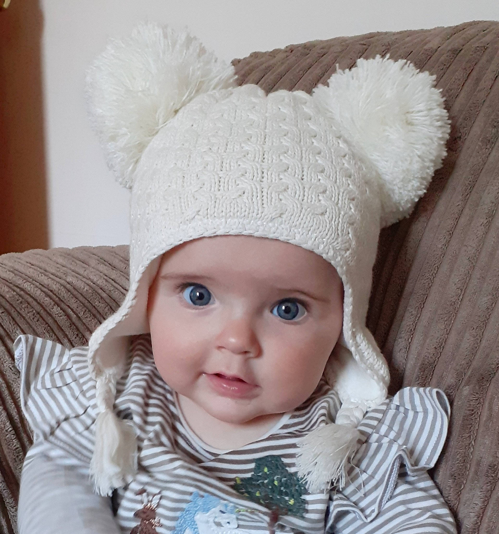 Emily joined the competition — help win amazing prizes! baby, baby_toddler_clothing, beanie, cap, cheek, child, eye, fashion_accessory, hairstyle, head, headgear, headwear, knit_cap, lip, outerwear, pattern, person, sleeve, toddler, white