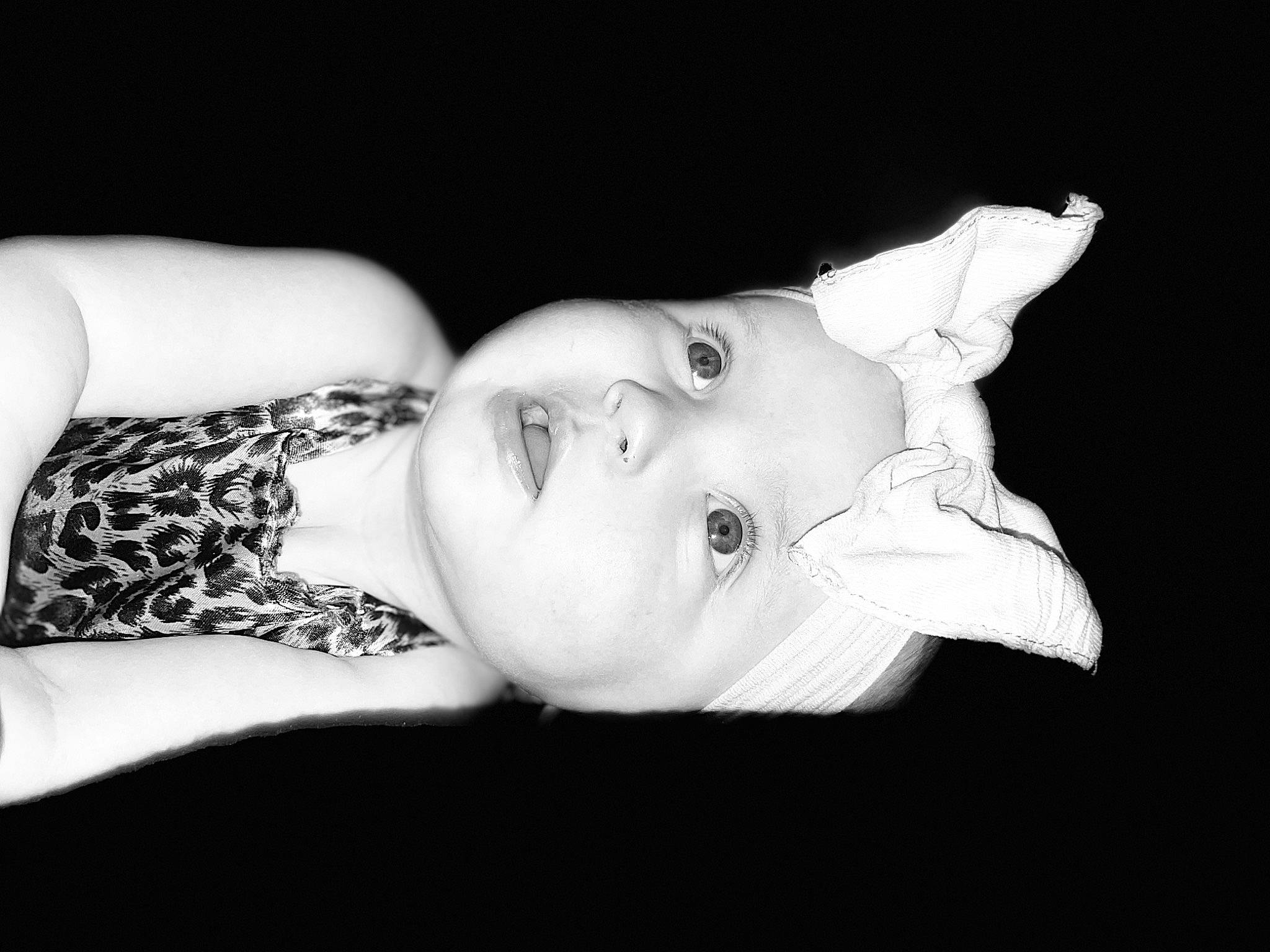 Jaylyn is registered to the contest to win money with this photo: baby, chest, child, darkness, eyelash, flash_photography, fur, gesture, grass, happy, headpiece, headwear, human_leg, monochrome, monochrome_photography, person, photo_shoot, portrait, portrait_photography, sitting