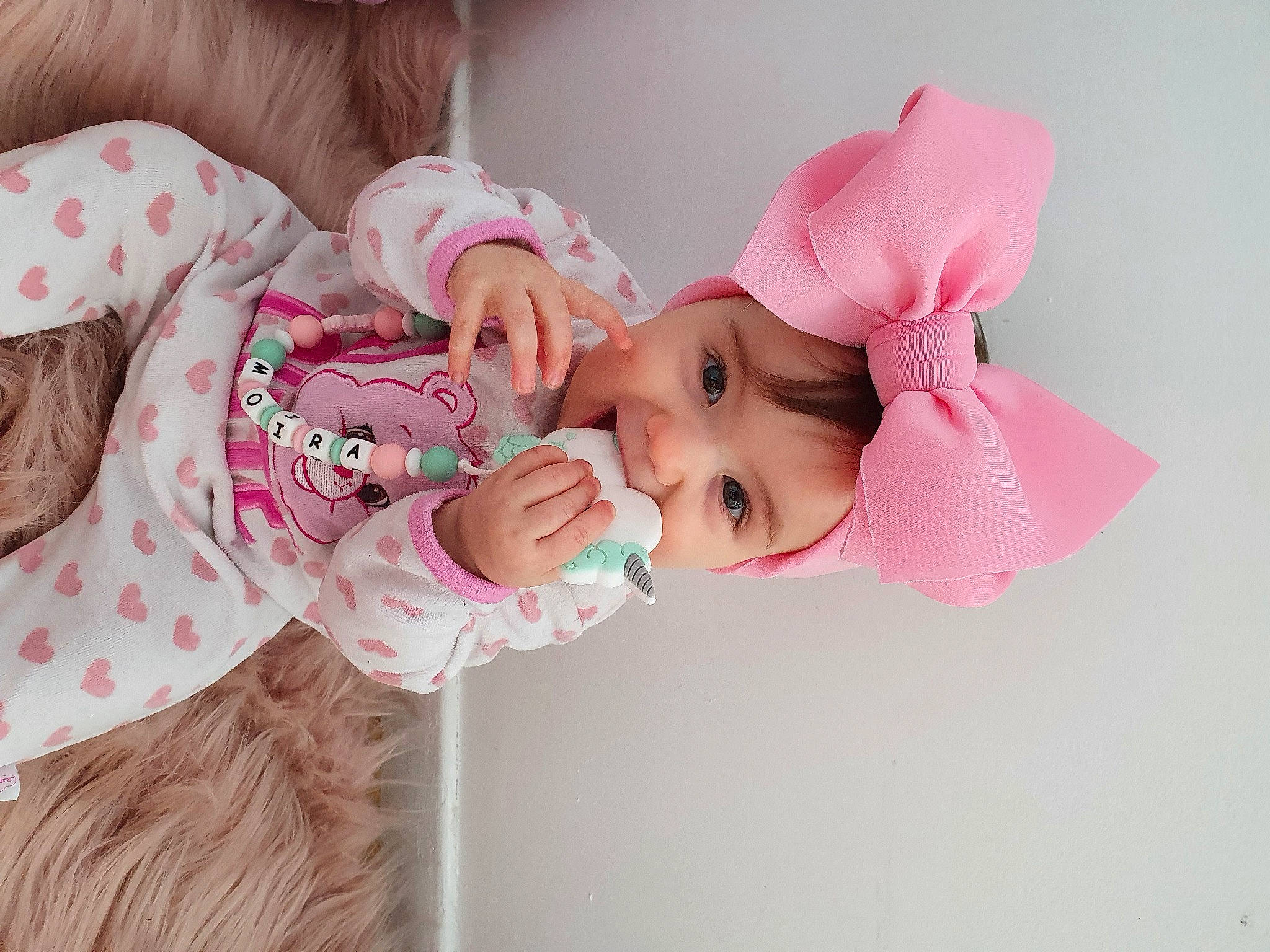 Moïra participe au concours pour gagner de l'argent avec cette photo : baby, baby_toddler_clothing, cheek, child, dress, eyelash, fashion_accessory, hair_accessory, happy, hat, headgear, headpiece, magenta, pattern, peach, person, pink, skin, sleeve, textile