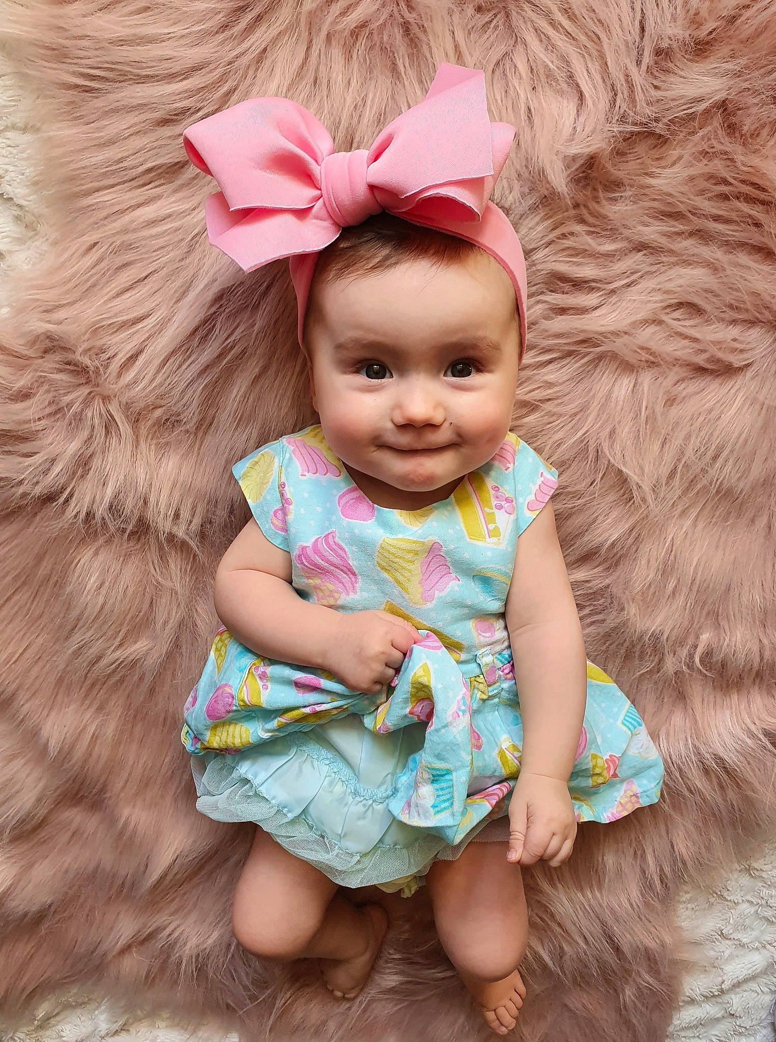 Moïra participe au concours pour gagner de l'argent avec cette photo : baby, baby_toddler_clothing, child, dress, eyelash, face, fawn, grass, happy, head, iris, joy, neck, outerwear, person, pink, skin, sleeve, smile, textile