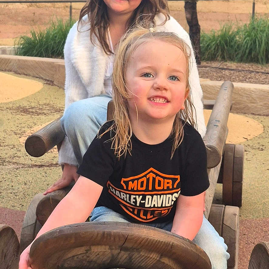 Ruby joined the competition — help win amazing prizes! child, children, outdoor, playground, wooden_toy, toy_car, steering_wheel, happy, smiling, casual_clothing, nature, grass, tree, daylight, fun, friends, park, wood, person, play