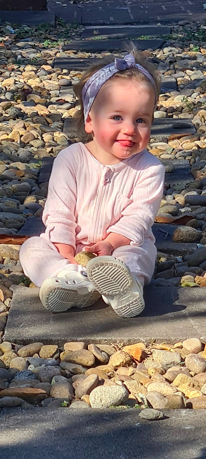 Ruby joined the competition — help win amazing prizes! baby, clothing, face, footwear, gravel, head, pants, path, pebble, person, photography, portrait, road, rock, shoe, sitting, slate, sneaker, soil, walkway