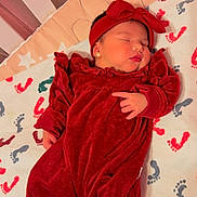 Mariangel Marín joined the competition — help win amazing prizes! baby, sleeping, red_outfit, headband, crib, blanket, footprints, newborn, infant, cozy, bedtime, cute, child, earrings, soft, indoors, resting, peaceful, portrait, sleep
