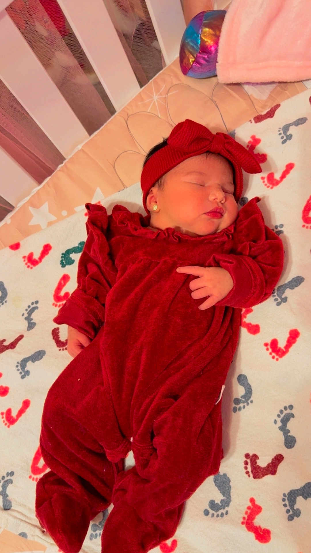 Mariangel Marín joined the competition — help win amazing prizes! baby, sleeping, red_outfit, headband, crib, blanket, footprints, newborn, infant, cozy, bedtime, cute, child, earrings, soft, indoors, resting, peaceful, portrait, sleep