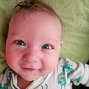 Jimmy is registered to the contest to win money with this photo: baby, infant, smiling, face, blue_eyes, onesie, caterpillar_print, hair, blanket, close_up, cute, child, happy, portrait, skin, lying_down, expression, soft_texture, indoors, person