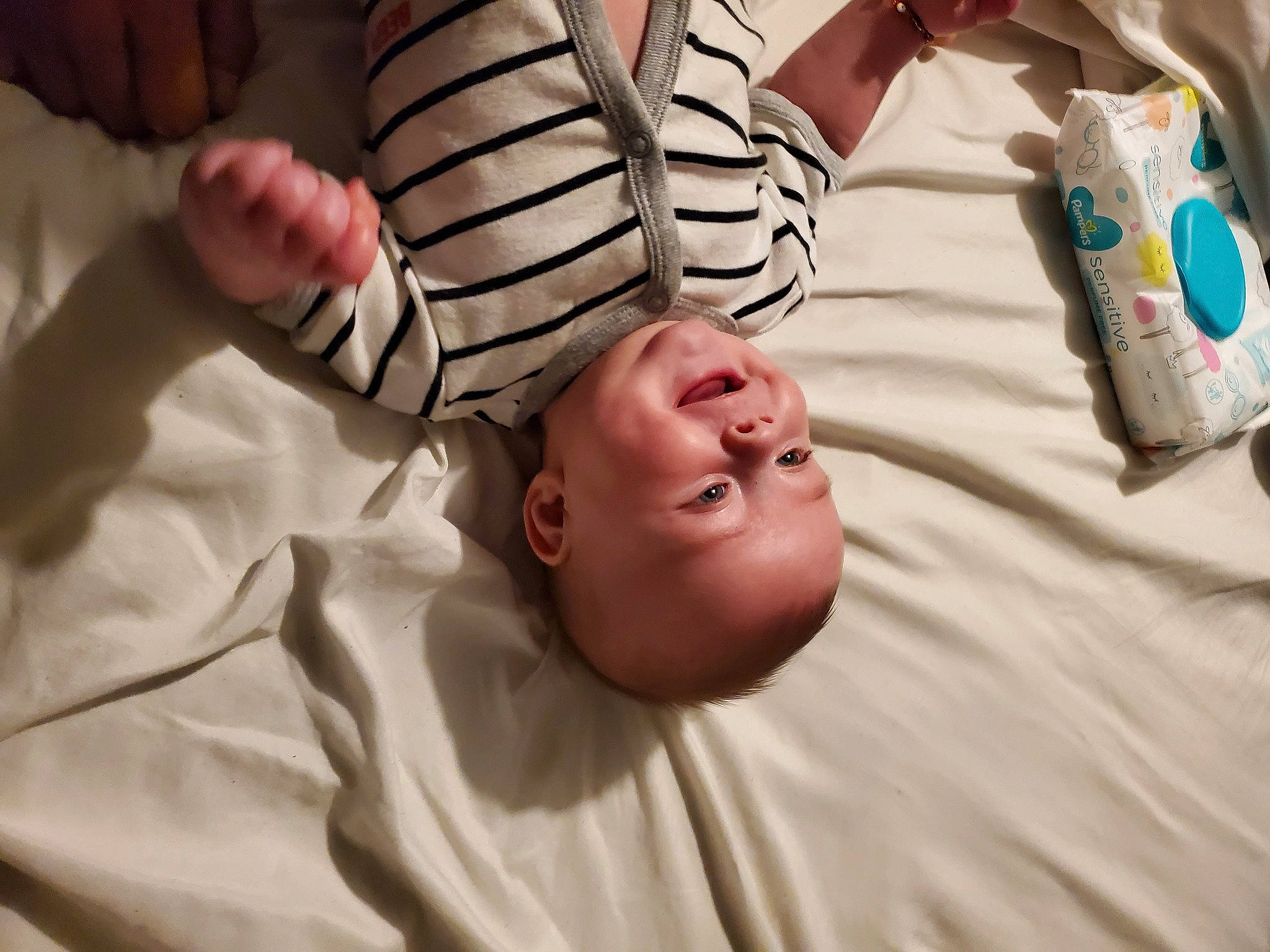 Alaric is registered to the contest to win money with this photo: baby, bed, bedding, child, comfort, elbow, finger, foot, fun, gesture, hand, happy, human_leg, linens, nail, person, smile, t_shirt, thigh, thumb