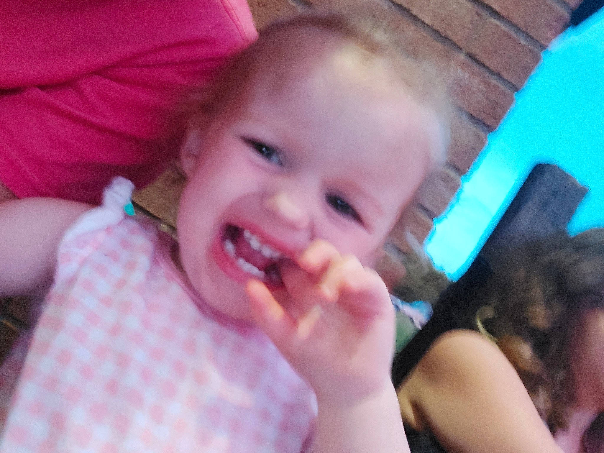 Coraline is registered to the contest to win money with this photo: baby, cheek, chin, ear, eyebrow, eyelash, finger, gesture, hairstyle, happy, iris, lip, mouth, nose, person, pink, skin, smile, toddler, tongue