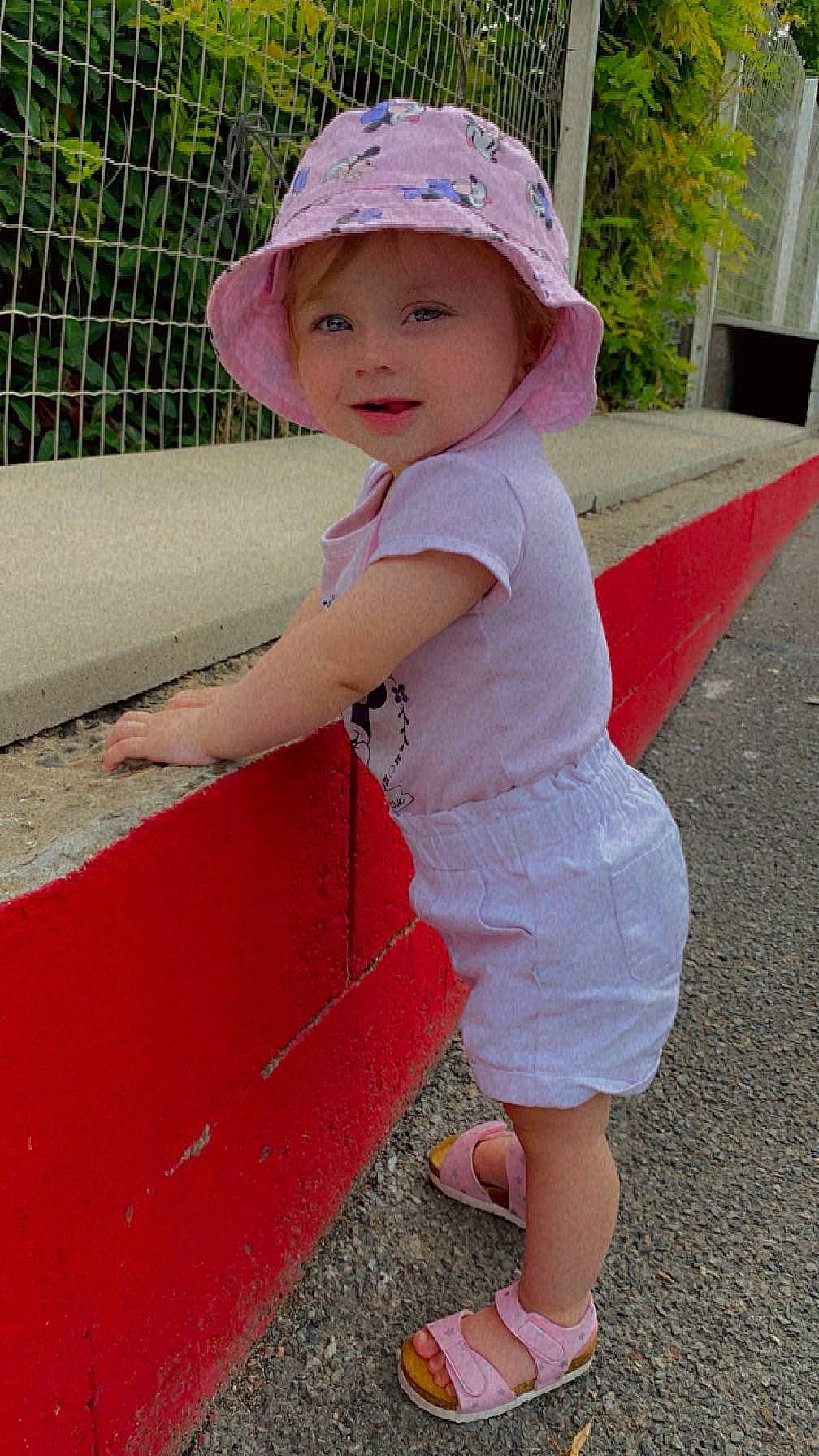 Stanciu Zemyra participe au concours pour gagner de l'argent avec cette photo : asphalt, baby_toddler_clothing, cap, child, clothing, face, fashion_accessory, fun, grass, hat, headwear, human_leg, leisure, magenta, mesh, person, pink, recreation, sandal, standing
