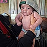 Montie joined the competition — help win amazing prizes! adult, baby, being_held, bottle, cap, child, curtains, diaper, face, family, furniture, home, indoors, infant, mesh_hat, photograph, portrait, sitting, standing, wood_paneling