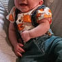 Mason joined the competition — help win amazing prizes! baby, smiling, infant, clothing, overalls, shirt, crab_pattern, seat, cushion, indoor, toy, colorful, child, happy, person, cute, cheerful, baby_seat, casual, portrait