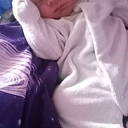 Mason joined the competition — help win amazing prizes! baby, newborn, sleeping, white_clothing, hat, pom_poms, blanket, purple, cozy, infant, cute, soft, peaceful, resting, child, person, bedtime, warm, snuggled, portrait