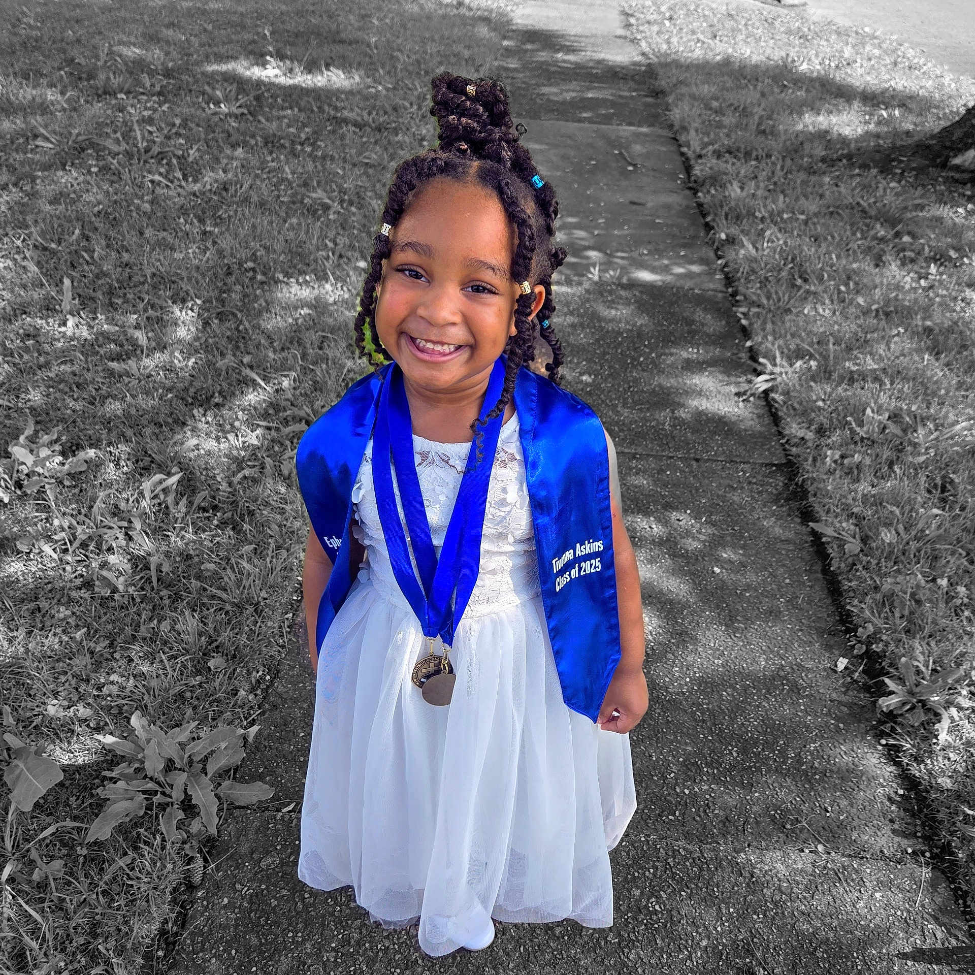 Tivonna is registered to the contest to win money with this photo: child, girl, smiling, white_dress, blue_stole, medal, outdoor, sidewalk, grass, celebration, portrait, happy, graduation, braided_hair, young, cute, person, festive, color_pop, sunlight