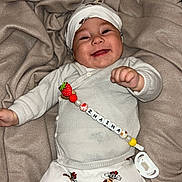 Zhaïna participe au concours pour gagner de l'argent avec cette photo : baby, smiling, infant, blanket, white_clothing, mickey_mouse, pacifier, pacifier_clip, headwear, cute, lying_down, happy, child, soft_texture, indoor, person, small_hands, buttoned_sweater, playful, cozy