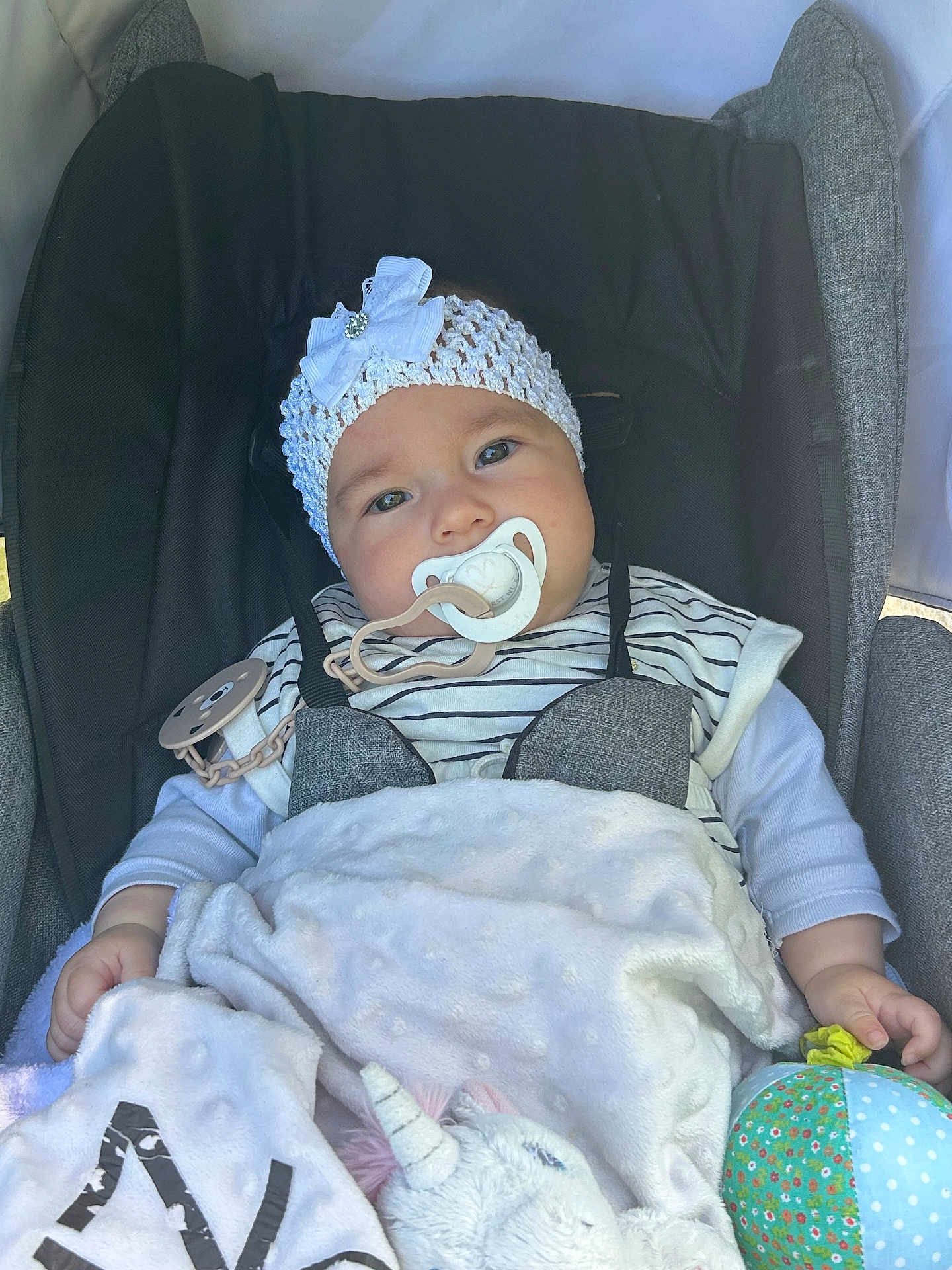 Zhaïna participe au concours pour gagner de l'argent avec cette photo : baby, pacifier, headband, bow, blanket, stroller, toy, unicorn, ball, striped_clothing, cushion, infant, child, cute, soft_texture, comfort, relaxed, indoors, portrait, wearing