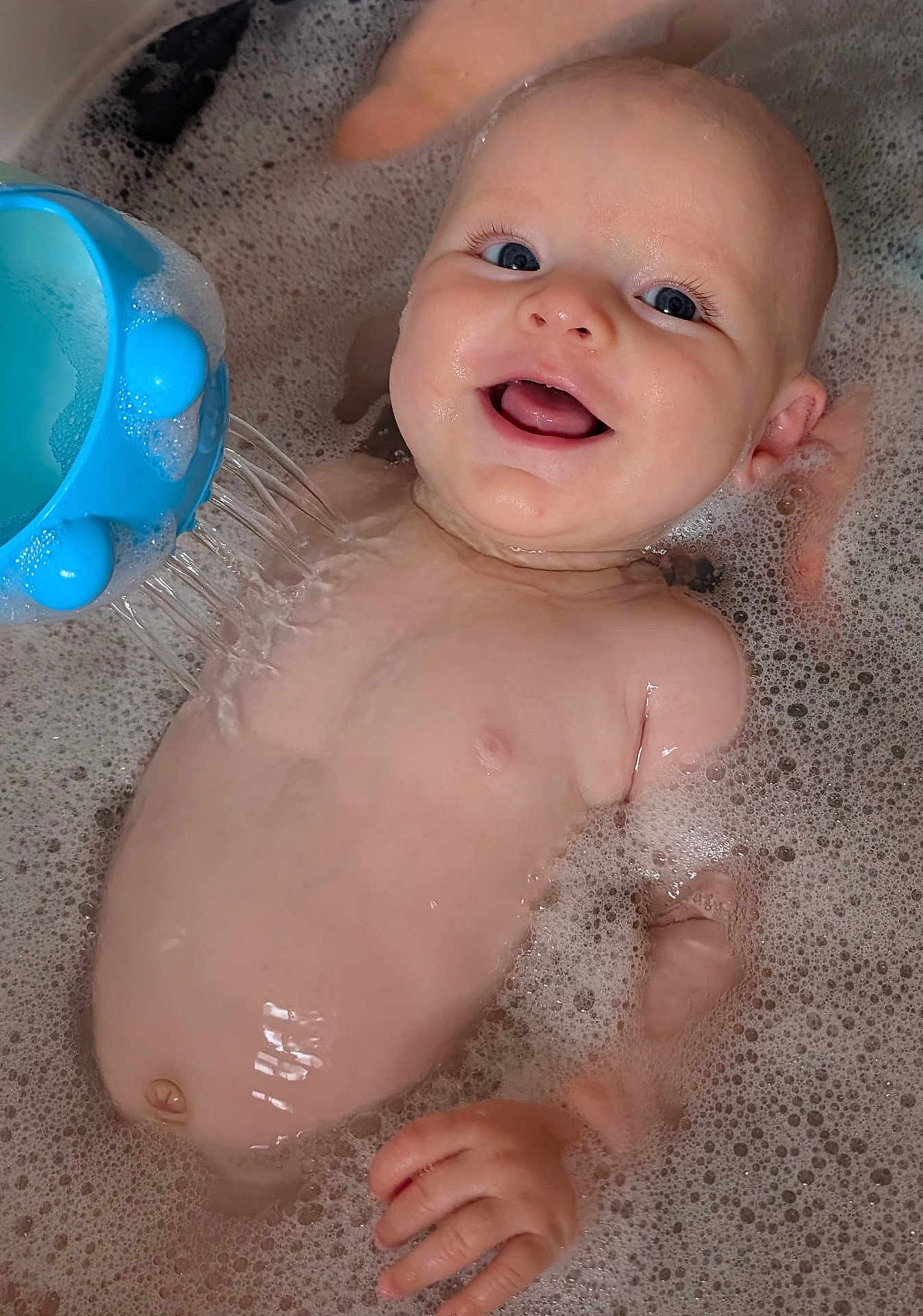 Dafydd is registered to the contest to win money with this photo: baby, bath, bubbles, water, toy, smile, happy, child, skin, face, hand, blue, play, fun, wet, cute, infant, water_toy, foam, relaxation