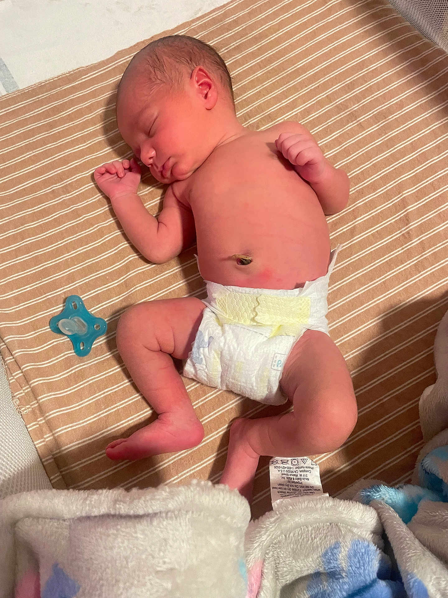 Jesrah is registered to the contest to win money with this photo: newborn, baby, sleeping, diaper, pacifier, blanket, striped_blanket, infant, skin, peaceful, lying_down, cozy, soft, cute, small, child, resting, indoors, human, toddler