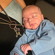 Jesrah joined the competition — help win amazing prizes! adult, baby, black_top, blue_clothing, caring, closeup, cozy, face, hand, holding, indoor, infant, keychain, necklace, peaceful, portrait, skin, sleeping, soft_focus, tender