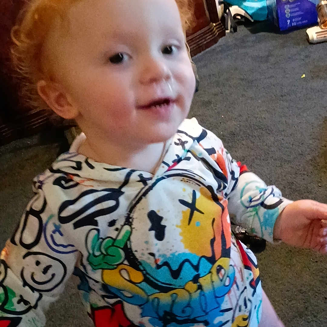 Paul Knight joined the competition — help win amazing prizes! barefoot, cabinet, candid, carpet, child, colorful_clothing, diaper, face, furniture, hoodie, household_items, indoor, person, playful, red_hair, room, smiling, toddler, toy, young_child