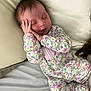 Lainey joined the competition — help win amazing prizes! baby, sleeping, floral_onesie, infant, bed, pillow, hand, peaceful, cute, child, resting, cozy, portrait, face, newborn, soft, indoors, person, relaxing, young