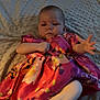 Tilly-May is registered to the contest to win money with this photo: baby, blanket, child, comfortable, cozy, cute, dress, expression, face, floral, hand, indoors, infant, laying, person, skin, sleepwear, soft_texture, white_pants, young