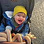 Dario participe au concours pour gagner de l'argent avec cette photo : baby, child, smiling, laughing, stroller, beanie, hat, denim_jacket, stuffed_animal, plush_toy, sunlight, outdoor, happy, face, teeth, seat, jacket, hand, toy, portrait