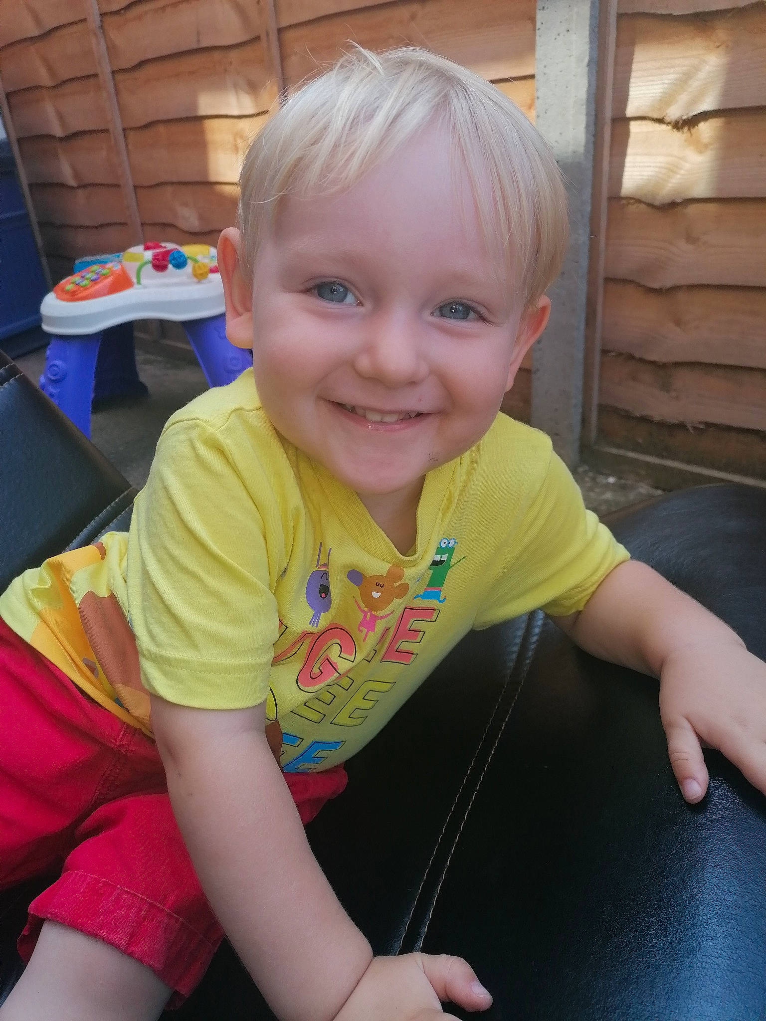 Jenson is registered to the contest to win money with this photo: baby_toddler_clothing, chair, cheek, child, chin, eye, facial_expression, fun, happy, iris, joy, leisure, mouth, nose, person, skin, sleeve, smile, t_shirt, thigh