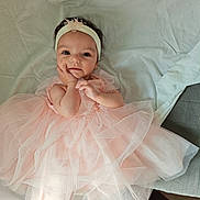 Ava a rejoint le concours — aidez-le/la à gagner de superbes lots ! baby, infant, headband, bow, pink_dress, tulle, dress, lying_down, bed_sheet, blanket, face, eyes, hand, toes, feet, smile, portrait, soft_light, adorable, fabric_texture