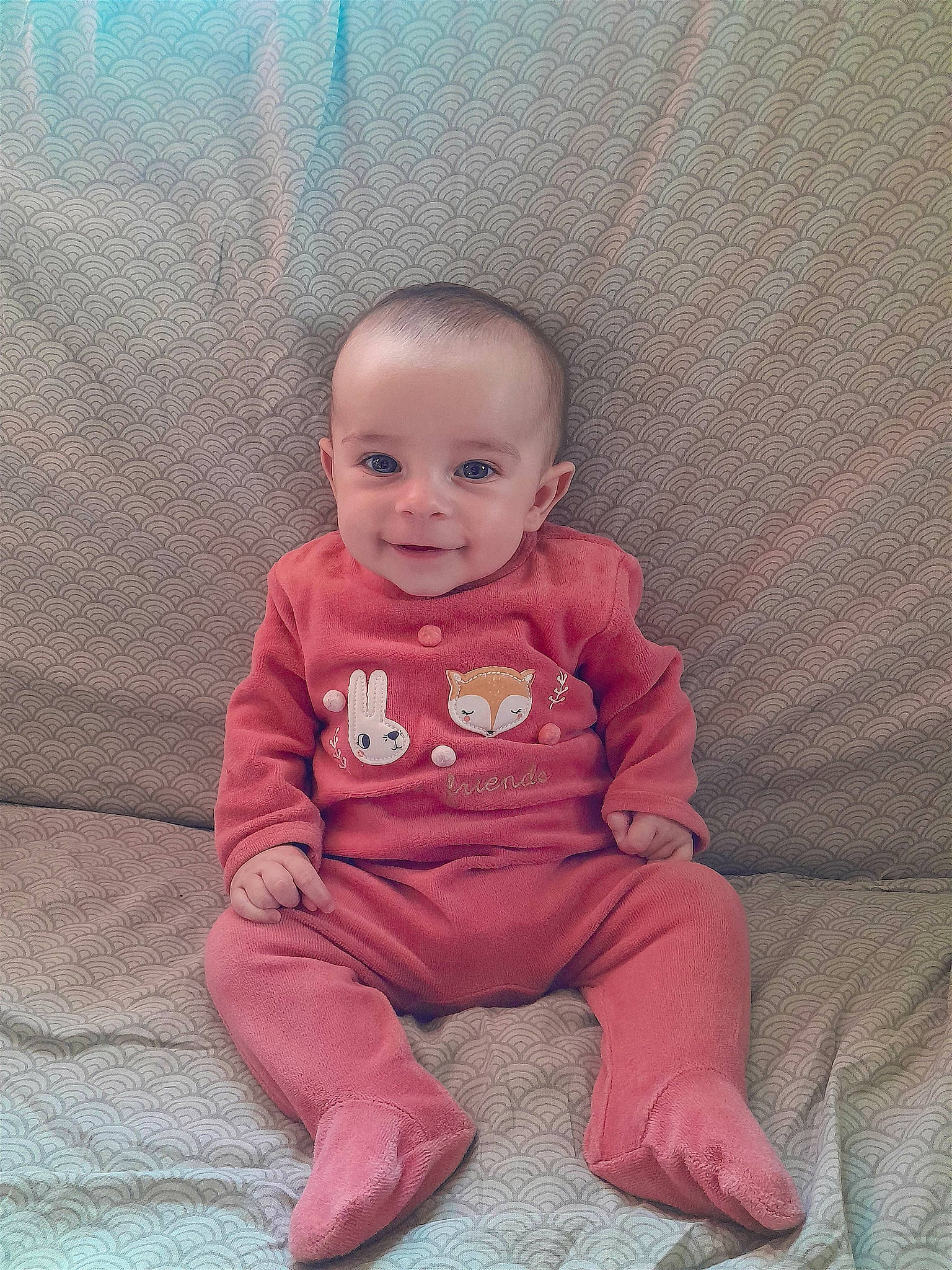 Cataleya participe au concours pour gagner de l'argent avec cette photo : baby, baby_toddler_clothing, carmine, cheek, child, comfort, eye, face, flooring, happy, joy, linens, long_sleeved_t_shirt, magenta, person, pink, sitting, skin, sleeve, smile
