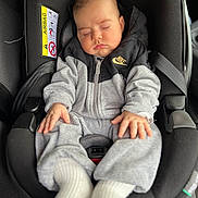 Yannis a rejoint le concours — aidez-le/la à gagner de superbes lots ! baby, sleeping, car_seat, hoodie, nike_logo, gray_clothing, white_socks, infant, child, seatbelt, car_interior, peaceful, hands, face, portrait, casual_wear, young_child, soft_lighting, cozy, resting