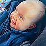 baby, child, smile, blue_hoodie, car_seat, face, infant, happy, cute, clothing, young_child, portrait, closeup, seatbelt, seat, head, skin, eyes, expression, indoors