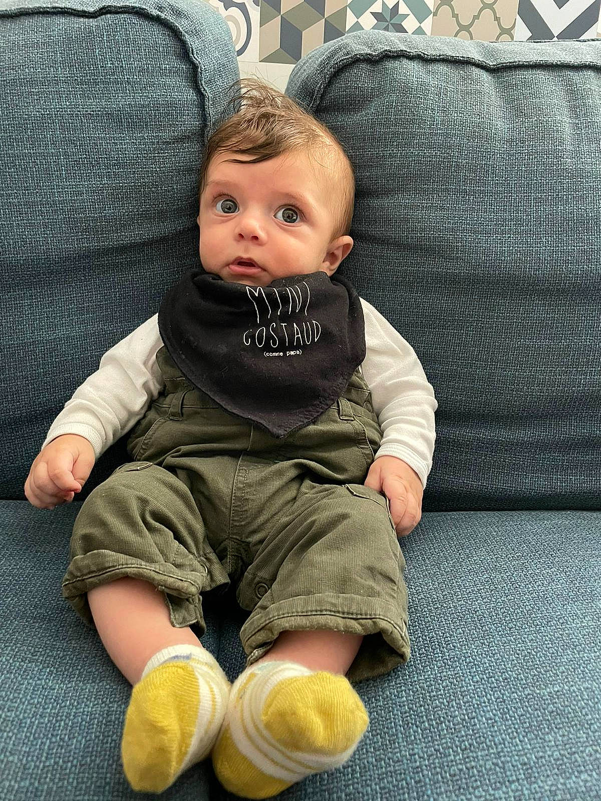 Augustin participe au concours pour gagner de l'argent avec cette photo : baby, baby_products, baby_toddler_clothing, cheek, child, comfort, couch, flooring, foot, green, human_leg, knee, lap, leg, person, room, sitting, skin, sleeve, sock