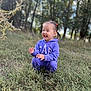 child, toddler, purple_hoodie, outdoor, grass, nature, smile, laughing, pigtails, greenery, trees, daylight, casual_clothing, happy, cute, young, person, squatting, field, sunlight