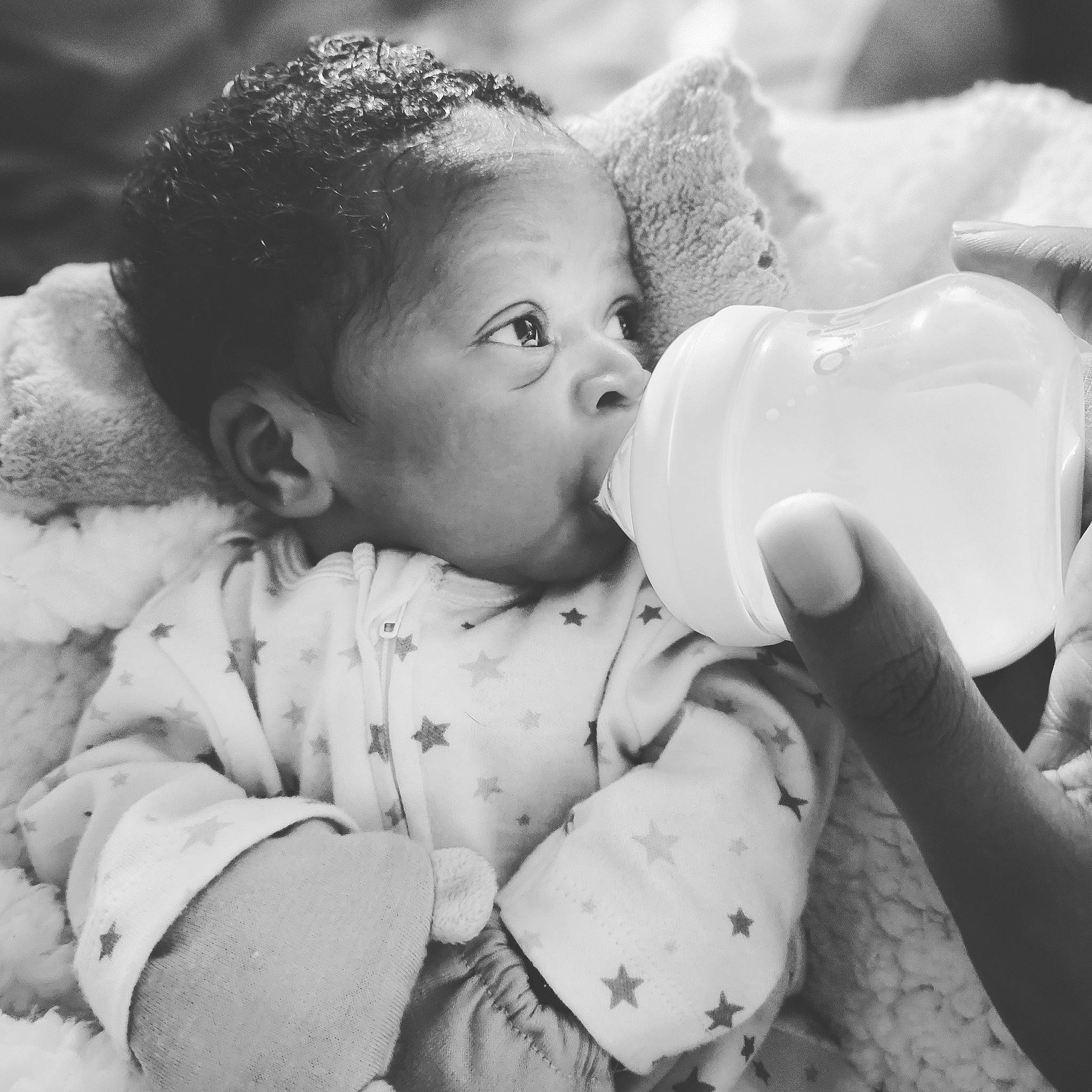 Valen is registered to the contest to win money with this photo: arm, baby, baby_bottle, black_and_white, bottle, cheek, child, drinkware, eyebrow, facial_expression, finger, gesture, hand, happy, human, monochrome, person, plastic_bottle, skin, style
