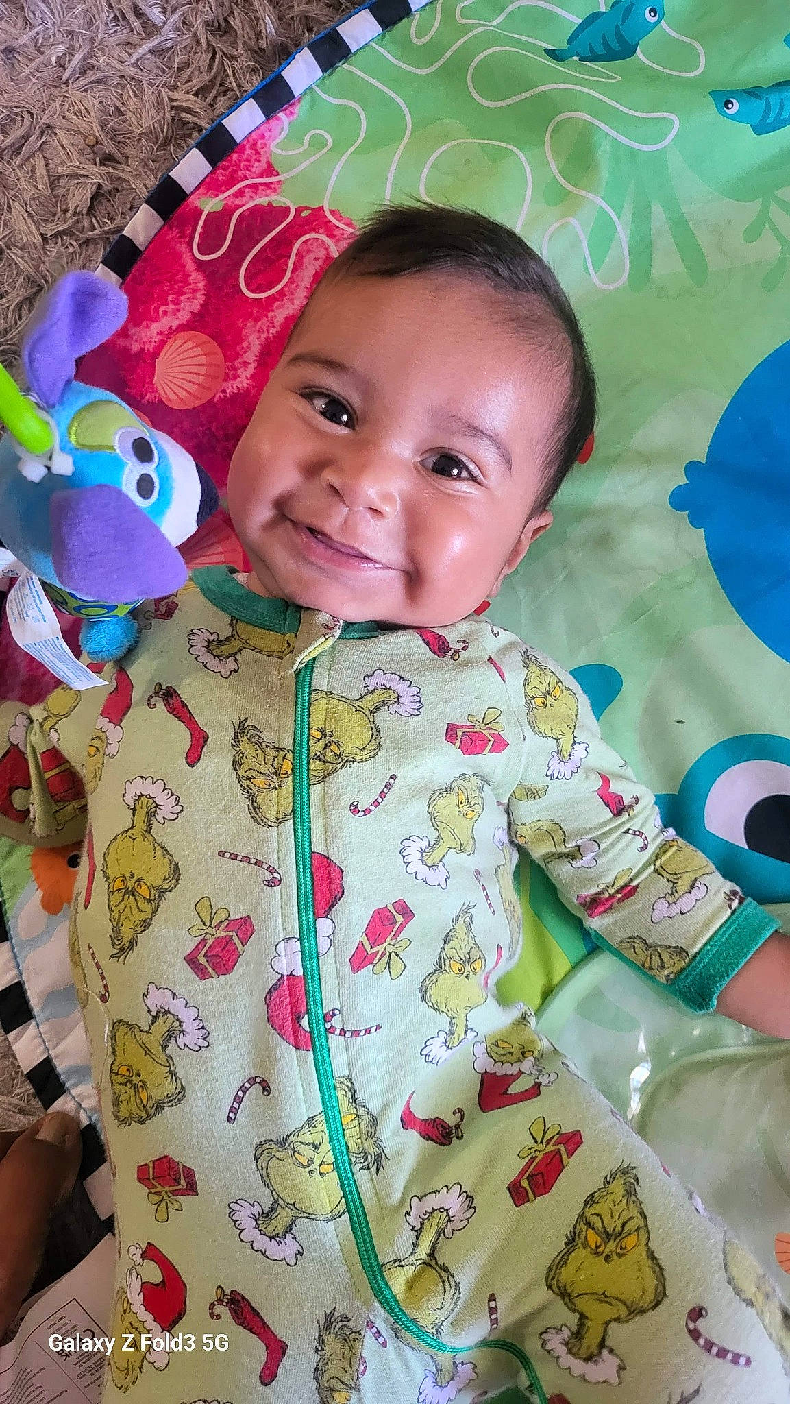 Santiago joined the competition — help win amazing prizes! baby, baby_toddler_clothing, cheek, child, face, facial_expression, green, happy, joy, linens, organ, outerwear, pattern, person, pink, product, skin, sleeve, smile, t_shirt
